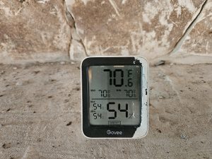 Measuring ambient temperature and relative humidity with a hygrometer to confirm interior conditions are consistent with wood flooring manufacturer requirements.