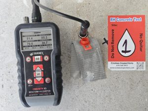 Using a Tramex relative humidity probe to verify that concrete slab moisture content meets manufacturer requirements, ensuring a stable subfloor for hardwood installation.