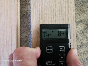 Measuring surface moisture of solid wood flooring with a Ligno Scanner prior to installation, confirming it meets manufacturer and jobsite specifications for optimal performance.